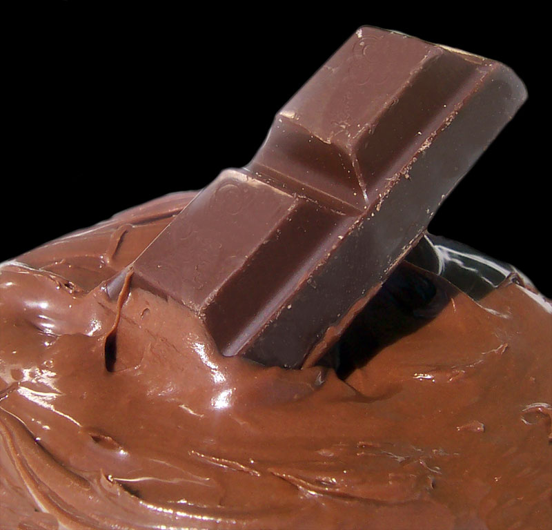 a bar of dark chocolate sitting in melted milk chocolate