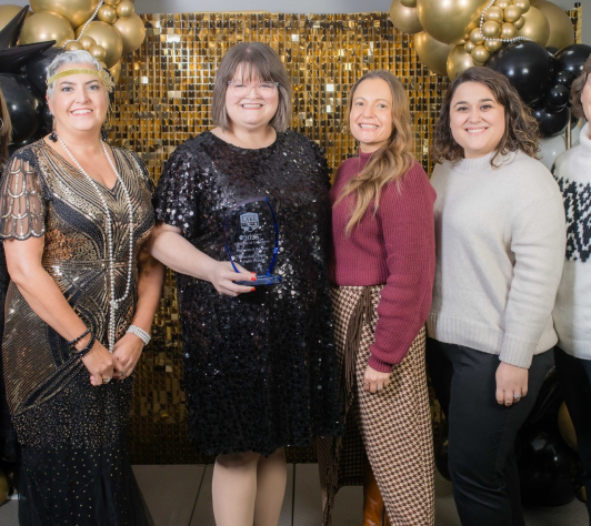 Photo of library employees and board members with the 2025 Business of the Year award